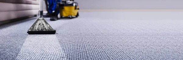 Carpet cleaning extractor working across a carpet